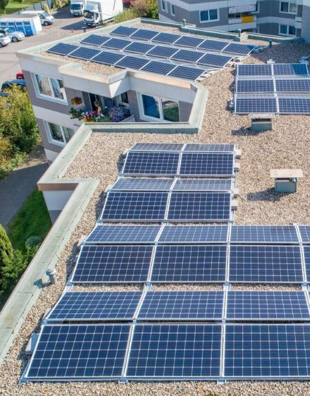 Solarpanele auf dem Dach von einem Mehrfamilienhaus